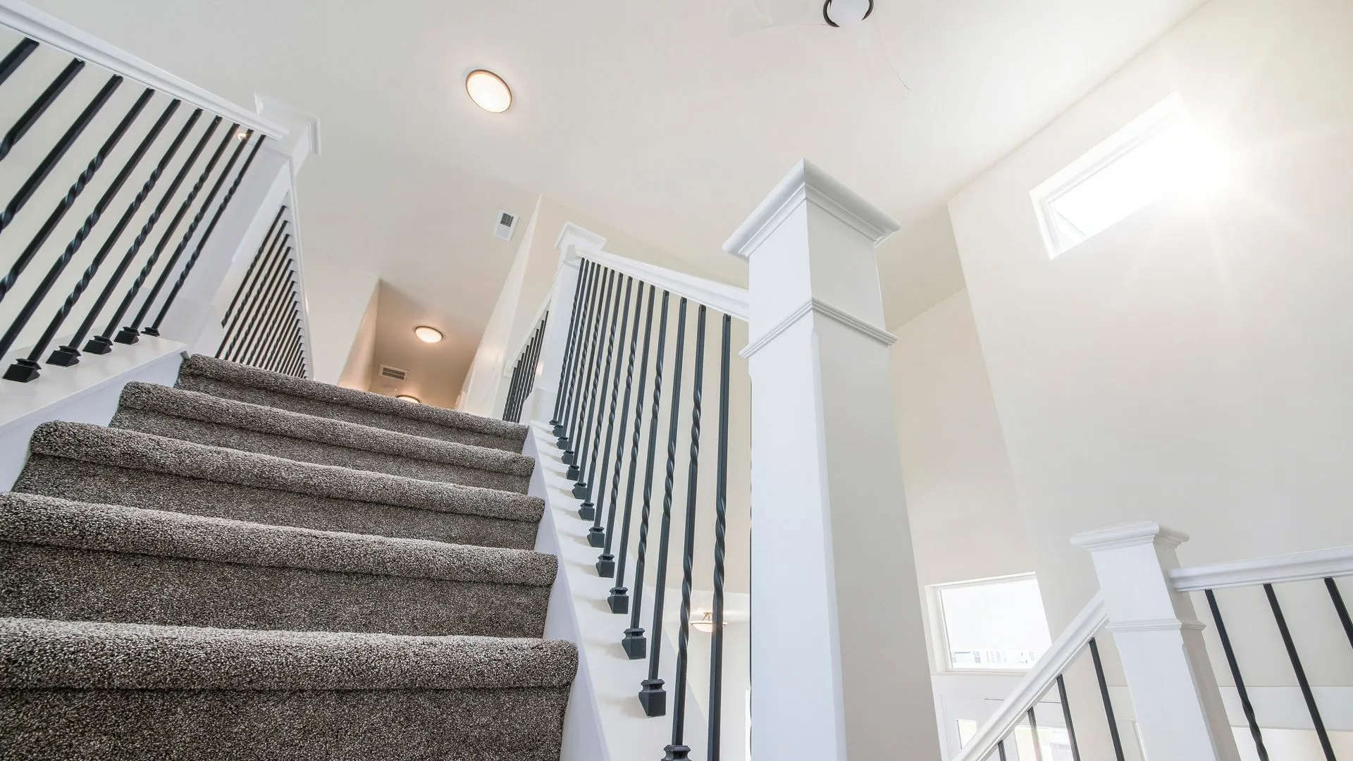 Interior staircase with black metal balusters and a finished handrail